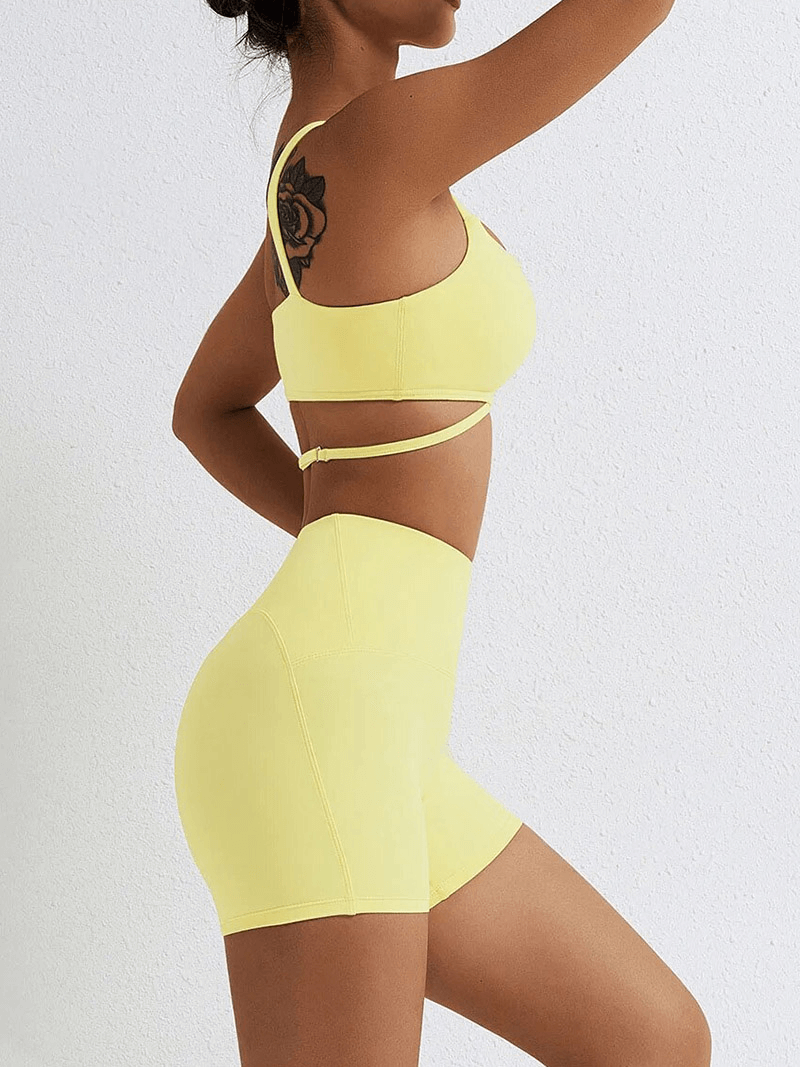 Model in yellow seamless gym sports suit with bra and shorts, perfect for yoga and fitness, made of nylon and spandex.